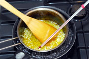 にんにくのみじん切り100gとオリーブオイル300ccを一緒に鍋に入れ、水を張った鍋にのせ、ゆっくり湯煎にかける。
