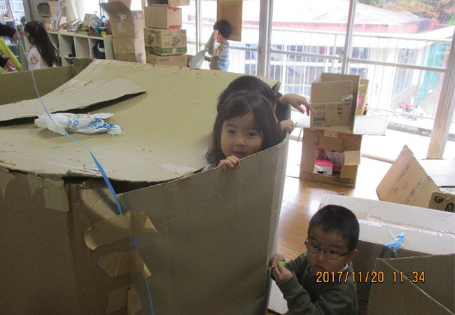 大きな段ボールで遊ぶ園児たちの様子