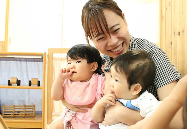 笑顔で園児たちを抱っこする受賞者の写真